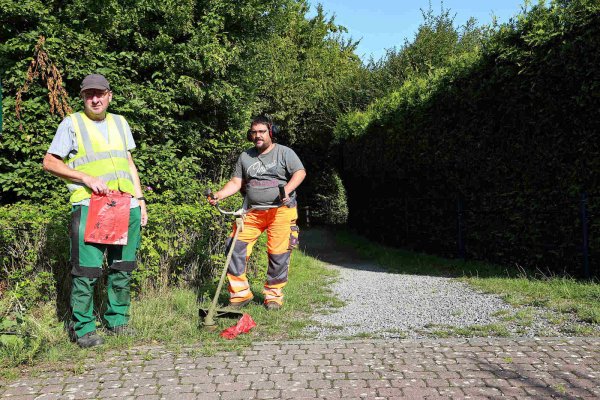 Rote Beutel: Wenn die Bauhofmitarbeiter Lothar Rottschäfer (links) und Christian Rentz mit einem Freischneider über einen gefüllten Beutel fahren, fliegt ihnen der Hundekot ins Gesicht. - © Thomas Dohna