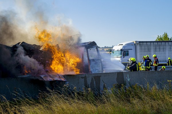 Feuerwehrleute löschen einen brennenden LKW, der nach einem technischen Defekt auf der A2 in Brand geraten ist. - © Stefan Simonsen/dpa
