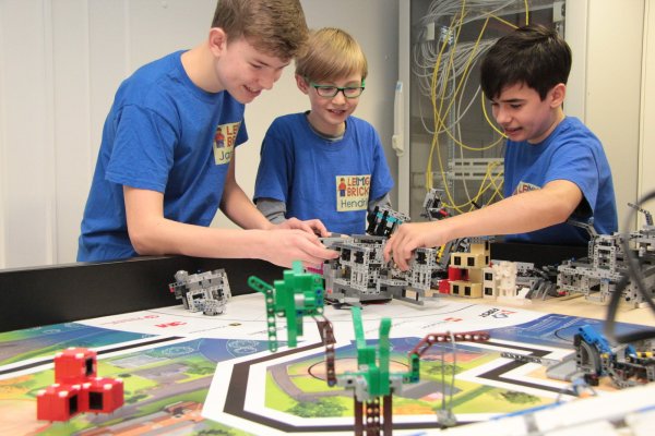Die Teammitglieder von Le(m)go Bricks (von links) Jannick Ahlvers (15), Hendrik Hanke (11) und Tarek Gröne (13) arbeiten an dem von ihnen entworfenen, gebauten und programmierten Roboter. Mit ihm sind sie beim Wettbewerb "First Lego League" angetreten. - © Carolin Brokmann-Förster