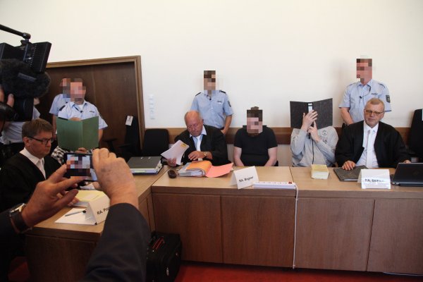 Die Angeklagten sitzen mit ihren Anwälten im Gerichtssaal (von links): Jann Henrik Popkes, Heiko V. (grüner Aktendeckel), Jürgen Bogner, Mario S., Andreas V. und Johannes Salmen. - © Bernhard Preuss