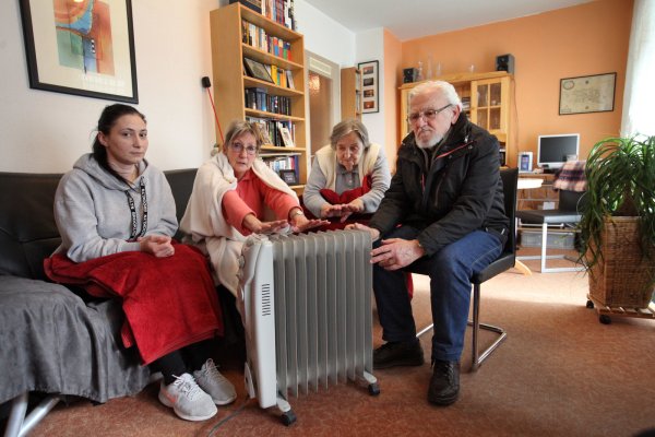 Seit Monaten sind kleine Elektro-Radiatoren die einzige Möglichkeit, ein wenig Wärme in die Wohnungen zu bekommen. Hier haben sich Juliane McCord (zweite von links) und ihre Haus- und Wohnungsnachbarn (von links) Yvonne Nieswand, Edith Bsdurrek und Julius Ursu in Juliane McCords Wohnzimmer versammelt, um von den Problemen bei der Sanierung zu berichten. - © Bernhard Preuß