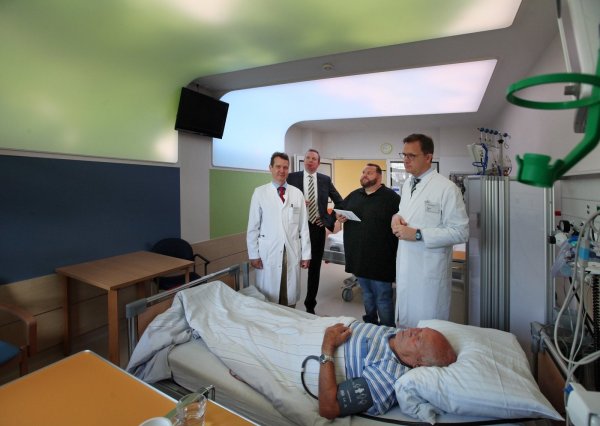 Willy Eickmeier, zurzeit Patient in Lemgo, mag die an lippischen Laubwald erinnernde Illumination der Decke am liebsten, verrät er (von links) Dr. Christoph Friedrich, Dr. Johannes Hütte, Jan Opel, der die Motivauswahl per Tablet steuern kann und Prof. Dr. Christoph Redecker. - © Bernhard Preuß