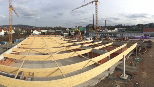 Neubau: Die fertigen Holzträger (verzerrt dargestellt durch die Panorama-Funktion) markieren in etwa die Fläche des künftigen Aldi. Dahinter Richtung Steinweg wird am Rewe noch gemauert und betoniert. - © Till Brand