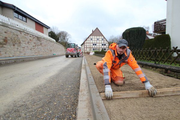 Valentino Perwan von der Firma Kemna arbeitet am Gehweg der Hohenhauser Straße. Links im Bild: ein Teil der Stützmauer. - © Jens Rademacher