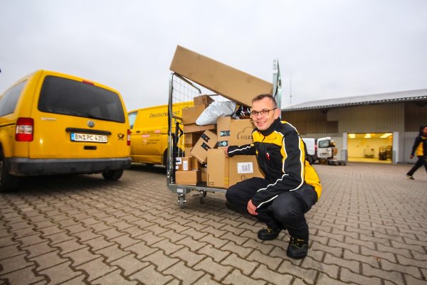 Mitarbeiter Ansgar Peine zieht aus der erweiterten Pakethalle ein Rollgitter mit Paketen zum Lieferwagen. Die Sendungen sind für Nieheim, Erwitzen und Holzhausen bestimmt. - © David Schellenberg
