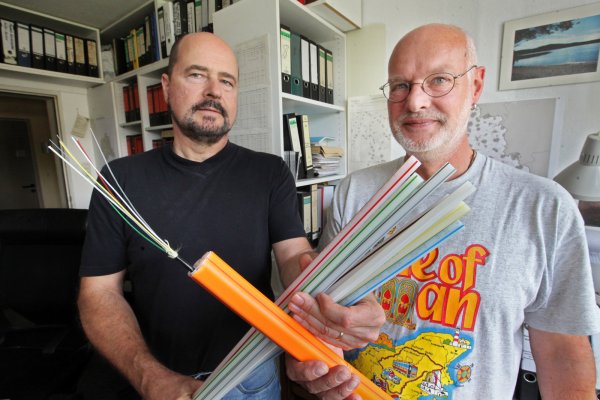 Breitbandausbau: Ulrich Stephanides (links) vom Kreis und André Gronemeier von der Stadt Detmold koordinieren im Kreis Lippe den geförderten Breitbandausbau und halten Glasfaserkabel in die Kamera. - © Bernhard Preuß