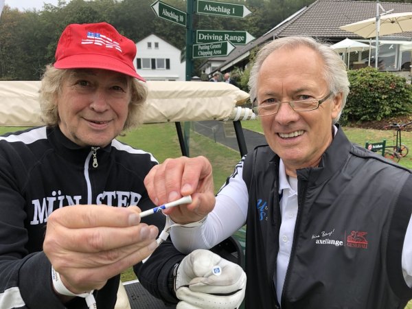 Bernd Wehmeyer (67, rechts), dreifacher Deutscher Meister mit dem HSV und Europapokalsieger der Landesmeister 1983, schlägt den Ball nur auf Hölzchen mit dem Vereinsemblem ab. Steffi Stephan (72), Bassist des Panikorchesters von Udo Lindenberg, freut sich über das kleine, aber feine Accessoire. - © Thomas Reineke