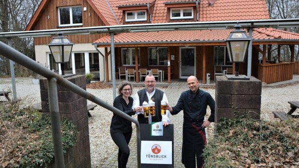 Serviceleiterin Simone Mohrenstecher, der neue Betreiber Robin Grote und Koch Boris Niemann (v. l.) stoßen auf das Gelingen des Neustarts im Berggasthof "Tönsblick" an. - © Karin Prignitz