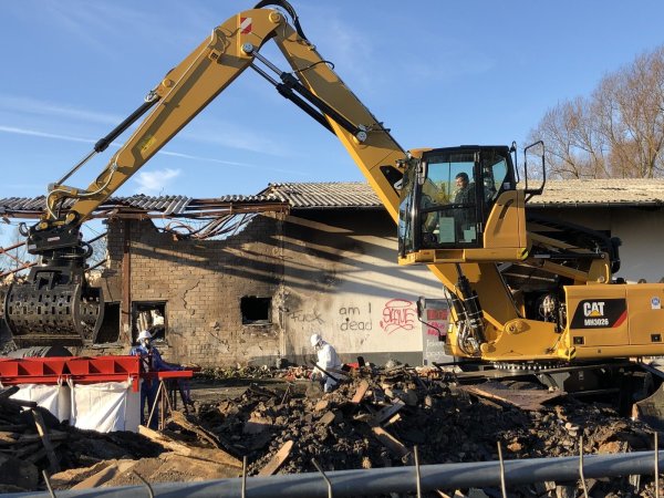 Nach wie vor bietet sich am Brandort an der Ladestraße ein apokalyptisches Bild. Während ein Bagger Schutt bewegt, spritzt Eugen Reiberg das Material ab, damit kein ungesunder Staub in die Luft gewirbelt wird. Fotos: Thomas Reineke - © Thomas Reinke