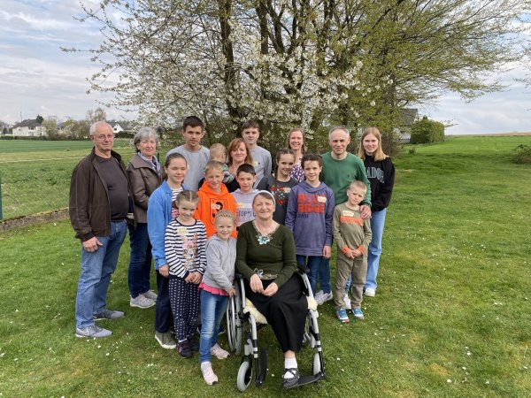 Johann und Helene Wins (links) unterstützen die Familie Korchak. Dazu gehören die Eltern Ludmilla und Igor sowie Großmutter Alla im Rollstuhl und die Kinder Alexander, Ernest, Victoria, Julia, Tatjana, David, Vladislaw, Daniel, Anna, Nicol und Yelisei. - © Dirk Windmöller