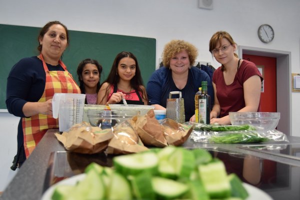 Gemeinsam gelingt die Gurkensuppe: (von links) Anna Sabokinova, Marie, Valya (alle Teilnehmer), Anne-Kathrin Edler (Komm. Integrationszentrum) und Caroline Giesler (Stadt HBM) schnippeln fleißig mit beim Kochtreff. - © Greta Wiedemeier