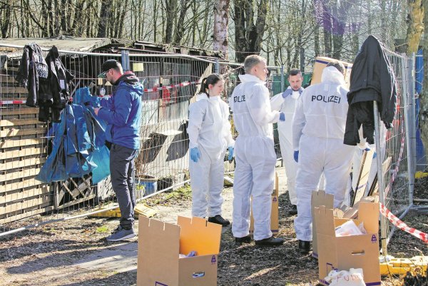 Am Tatort: Polizisten in Schutzanzügen bringen das Inventar der Baracke von Andreas V. in einen Container. - © Bernhard Preuß