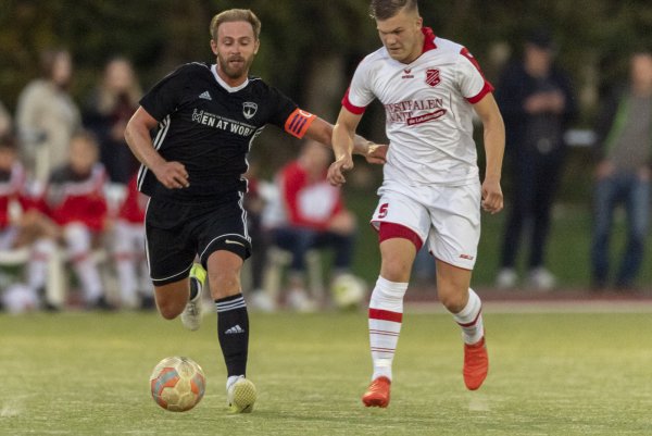 Zentrale - Der Postler Johann Felker(links, schwarz) und sein Steinhagener Kontrahent Jonas Böhme (weiß, rechts) im Laufduell um den Ball. Foto: Egon Penner. - © Egon Penner