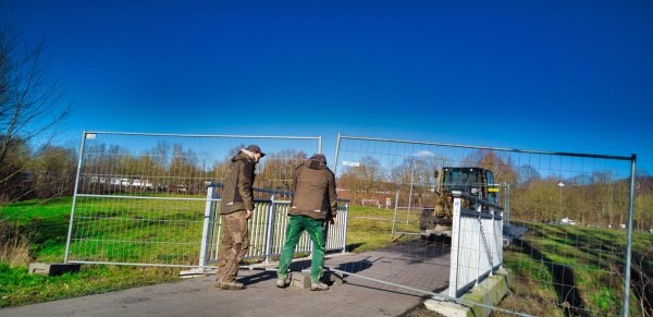 An dem Fußweg an der Emmer werden Bauzäune als Absperrungen aufgebaut. Die Fußgänger und Radfahrer werden durch den Schlosspark umgeleitet. - © Wolfgang Furmanski
