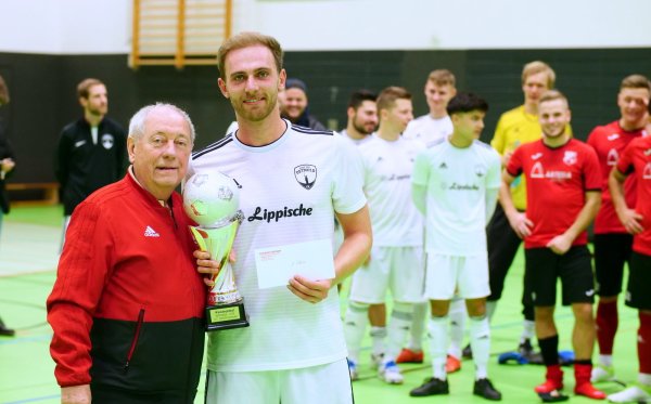 Wieder ein Pokal für den Post-TSV Detmold: Türkgücü-Vorsitzender Paul Wolfgang Herrmann überreicht die Siegprämie des Everdi-Reisen-Cup an Johann Felker. - © Jörg Hagemann