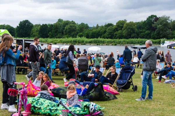 Die Besucher haben sich das Fingerfood zum Verweilen mitgenommen - und es sich am Seeufer gemütlich gemacht. - © Raphael Bartling