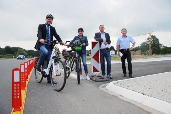 Bürgermeister Jürgen Schell, 
Conny Hagen von der Lebenshilfe sowie Tobias Fischer und Dietmar 
Stölting von „Straßen.NRW"  (von links) präsentieren am 22. Juni auf einem Pressetermin, dass sie mit dem Provisorium 
während der Bauzeit mehr Sicherheit für Radler bieten. - © Katrin Kantelberg