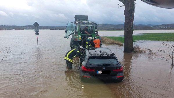 Das Wasser steht dem Feuerwehrmann bis zum Oberschenkel. Alleine hätten sich die Insassen des Autos wohl nicht befreien können. - © Feuerwehr Porta/Michael Horst