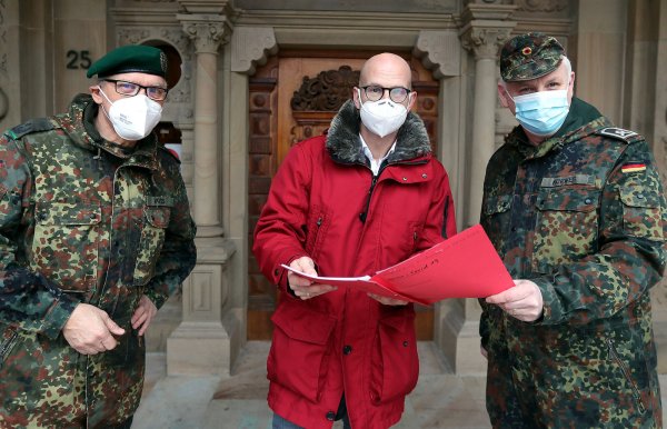Vor gut einem Jahr war die Bundeswehr erstmals in Bielefeld im Corona-Einsatz. Krisenstabschef Ingo Nürnberger (Mi.) empfing damals Andreas Voss (li.) und Alfred Korwes (r.) vor dem Alten Rathaus. - © Wolfgang Rudolf
