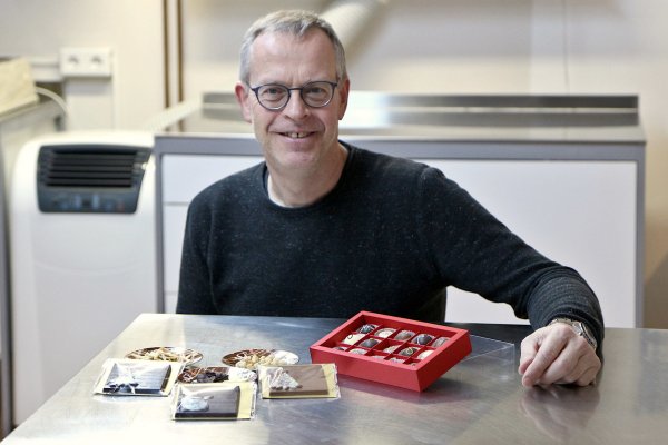 Konditormeister Achim Deppermann zeigte Vorprodukte und fertige Pralinen. Links auf den Tellern liegen Haselnüsse, Mandelsplitter und verschiedene Sorten Schokolade in Plättchen. Davor liege Täfelchen mit Weihnachtsmotive, rechts Pralinen aus der Werkstatt Deppermanns.  - © Thomas Dohna