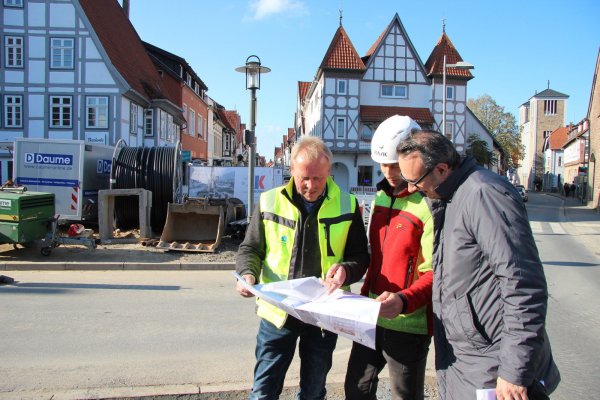 Ein Blick auf die Pläne: Die zeigen Klaus Hagemeister (von links), Norman Heidschuster und Markus Baier, was am Ostertor mit Sitzmauer, Brunnen und Bäumen noch geschehen soll. Alle Geschäfte sind während der Bauarbeiten zu erreichen. - © Katrin Kantelberg