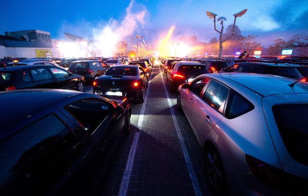 Gäste parken mit ihren Autos während einer Auto-Disco auf dem Parkplatz der Diskothek. - © picture alliance/dpa