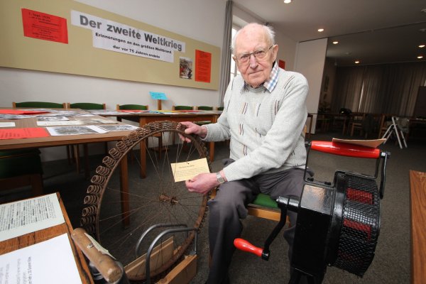 Helmuth Welsch mit Exponaten wie einer Luftschutzsirene aus dem Zweiten Weltkrieg (rechts) und einem Fahrradreifen mit Spiralenfedern aus Metall. Sie sind im Heimatmuseum Alverdissen zu sehen. - © Jens Rademacher