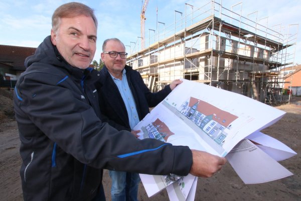 Andreas Kelle, Gesellschafter der Kelle Wohnwert GmbH, und Milko Kemmler (von links), Inhaber der ambulanten Kranken- und Altenpflege "Pflege vor Ort", stehen auf der Baustelle in Heidenoldendorf und sehen sich Ansichten des Hauses an, in dem altengerechte Wohnungen und eine Wohngruppe für Pflegebedürftige entstehen werden. - © Patrick Bockwinkel