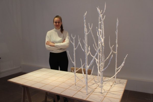 Einblick in die Ausstellung: Stipendiatin Paloma Riewe zeigt einen Tisch, aus dem Pflanzen empor zu wachsen scheinen.  - © Michaela Weisse