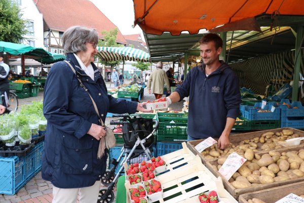 Im Kundengespräch: Margarete Denk kauft Erdbeeren am Stand von Andreas Plaß. Beide sehen den Verkehrsversuch eher skeptisch. Die Beschicker befürchten, Kunden einzubüßen. - © Alexandra Schaller