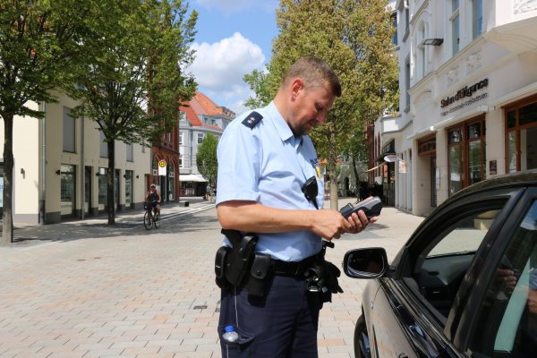 Angehalten: Bezirksbeamter Andreas Grabbe kontrolliert im Bereich „Am Markt" einen Fahrzeughalter, der in die Fußgängerzone eingefahren ist. - © Alexandra Schaller