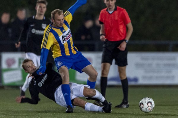 Konsequenter Einsatz - Der Jerxer Magnus Diekmann (schwarz, links) grätscht gegen den Lügder Kris Pape (gelb, rechts) vor den Augen des Schiedsrichters Jan Ole Krüger (rot) den Ball weg. Foto: Egon Penner - © Egon Penner