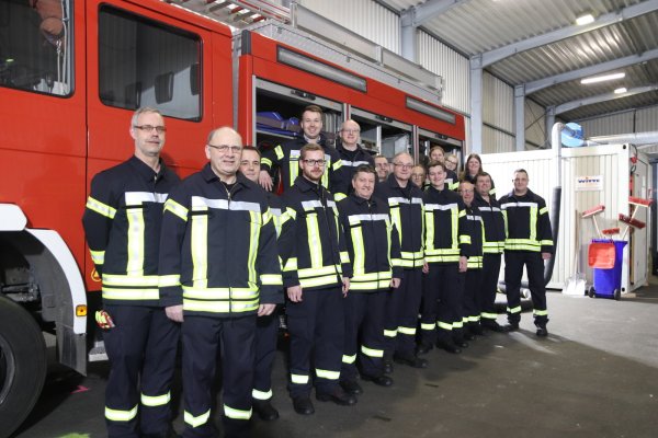 Ein Großteil der rund 25 Feuerwehrfrauen und -männer steht an dem Fahrzeug, mit dem sie im Notfall von Asemissen aus ausrücken. Hinten rechts sind die Container zu sehen, in denen Umkleiden und Toiletten untergebracht sind. - © Birgit Guhlke