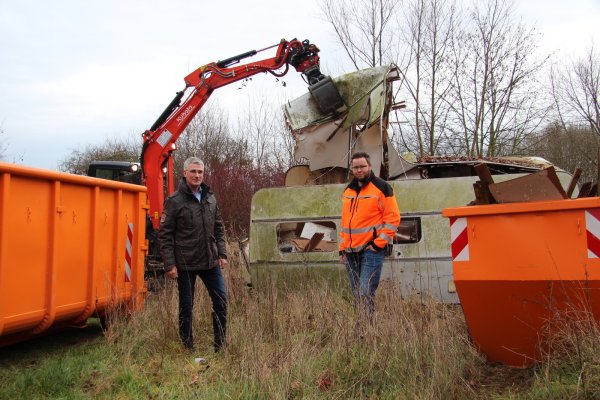 Städtischer Beigeordneter Thorsten Paulussen (links) und Bauhofleiter Leif Salitter freuen sich, dass die Räumung der wilden Kleingärten nun endlich beginnen kann. Im Hintergrund reißt Simon Eichhorn mit dem Bagger einen alten Bauwagen auseinander. - © Nadine Uphoff