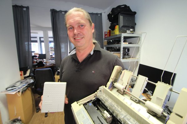 Relikte aus mehr oder weniger alten Computer-Zeiten: Experte Heiko Dross zeigt eine alte ISDN-Box für den Zugang ins Internet und einen Epson-Nadeldrucker aus den 90er Jahren. - © Jens Rademacher