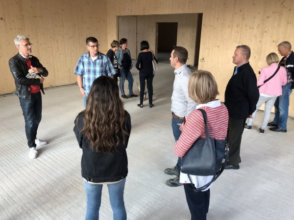 Ortsbegehung: Ronald Achtsnick (links) führt die Mitglieder des Ortsausschusses Werl-Aspe durch den Neubau der Realschule. Wände und Decken der Lernhäuser sind auch innen komplett mit Holz ausgekleidet. Der Fußboden muss noch gemacht werden. - © Sven Kienscherf