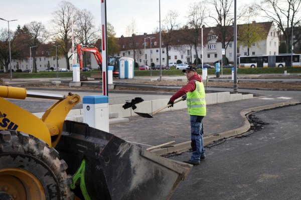Der neue Parkplatz an der Hornschen Straße geht seiner Vollendung entgegen. Zu den letzten Arbeiten, die Marvin Mumot von der Bau-Union Lippe erledigt, gehört die Säuberung der Fahrbahnkanten von Asphaltresten - © Bernhard Preuss