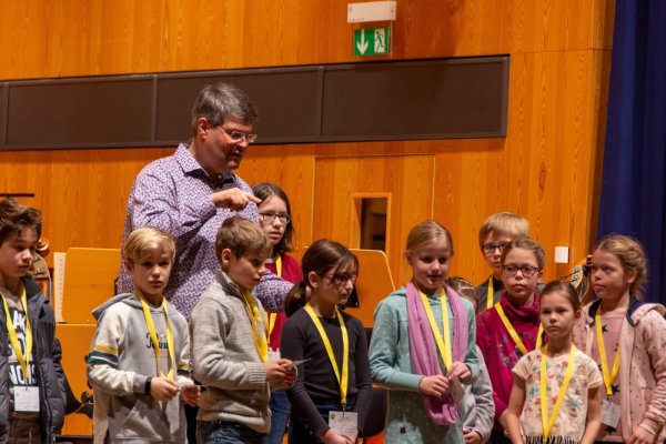 Prof. Florian Ludwig von der Detmolder Hochschule für Musik bringt den Kinderuni-Teilnehmern die grundlegenden Handgriffe eines Dirigenten bei. - © Raphael Bartling
