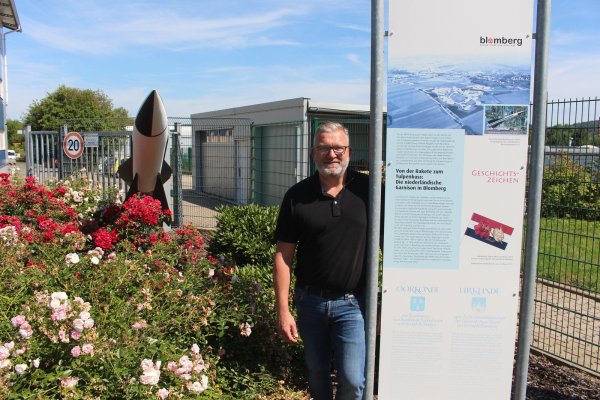 Christian Veenstra zeigt die Tafel und den Dummy einer Flugabewehrrakte, die an die Stationierung der Niederländer erinnert. Die Rakete steht im heutigen Gewerbegebiet "Nederlandpark". Damals war es der Standort der Kaserne. - © Michaela Weiße