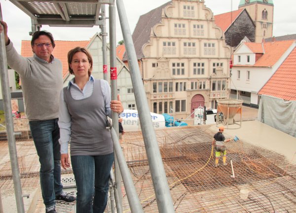 In altehrwürdiger Nachbarschaft: Architekt Reinhard Schwakenberg und die künftige Hotelchefin Tina Langner stehen auf dem Gerüst des hinteren Gebäudeteils des neuen Hotels Annenhof – hinter ihnen wird gerade die Decke der Lobby betoniert. Hexenbürgermeisterhaus und Kirche St. Marien sind nur einen Steinwurf entfernt. Foto: Till Brand - © Till Brand