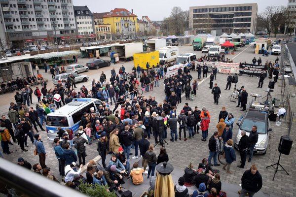Kesselbrink im Überblick: Für Demo-Anmelder Ralph Lange fungierte ein Auto-Anhänger als Redner-Bühne (r.). Er selbst konnte kaum Mitstreiter mobilisieren – rund um die Absperrbänder herum formierte sich dagegen größerer Gegenprotest. - © Barbara Franke