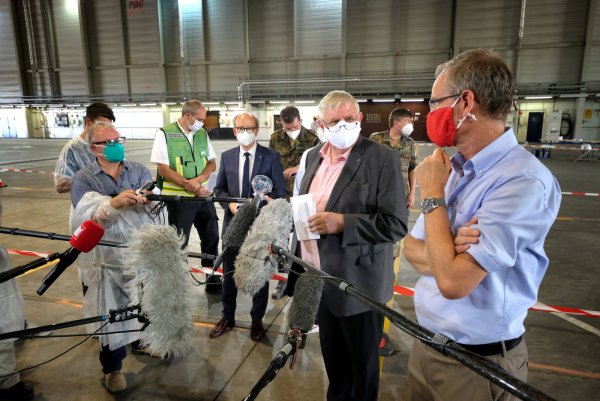 NRW-Gesundheitsminitser Karl-Josef Laumann (Mitte) sucht auf dem Flughafengelände in Gütersloh das Gespräch mit Landrat Sven-Georg Adenauer. Im Hintergrund ist Landtagspräsident André Kuper zu sehen. - © Andreas Frücht