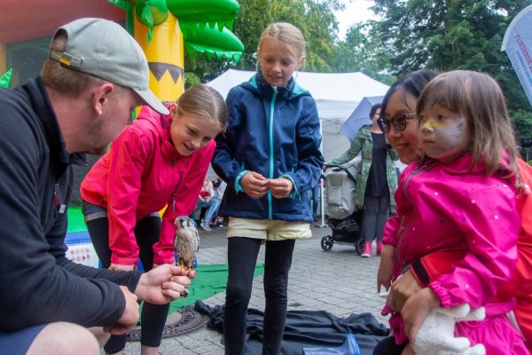 Unser Bild zeigt (von links) Tierpfleger Jonas Feist mit Mareen (11), Jana (10), Zijie Liao und Helen (3), die einen jungen Buntfalken anschauen. - © Raphael Bartling
