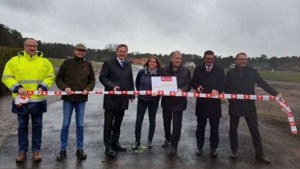 Scharfer Schnitt: Bürgermeister Dr. Andreas J. Wulf (Dritter von links) und Arnd Paas (Sparkasse Paderborn-Detmold, Zweiter von rechts) durchschneiden das Absperrband. Mit ihnen freuen sich (von links) Manfred Wagner (Tiefbauamt), Armin Zimmermann (Betriebsleiter der Gemeindewerke), Susanne Hoffjann (Leiterin des Fachbereichs Bauen, Planen und Umwelt), Oliver Klitzke und Oleg Enns ( beide S Boden GmbH).  - © Gemeinde Augustdorf