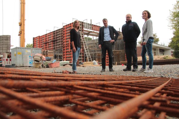 Der Umbau läuft: (von links) Isabell Matejek, Tagesstättenleiterin bei „Das Dach", Ortsausschussvorsitzender Thorsten Sagner, Feuerwehrchef Klaus Wegener und Architektin Regine Schmelzer von der Stadt sehen sich den Stand an der alten Schule Hörstmar an. Im Hintergrund entsteht die neue  Fahrzeughalle für die Feuerwehr mit ihren hohen Toren. - © Till Brand