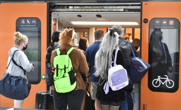 Bahnfahrer drängen sich am Sonntag am Eingang eines Regionalzuges am Deuter Bahnhof. Durch das 9-Euro-Ticket verzeichnet die Deutsche Bahn mehr ausgelastete Züge an Pfingsten. - © Roberto Pfeil/dpa