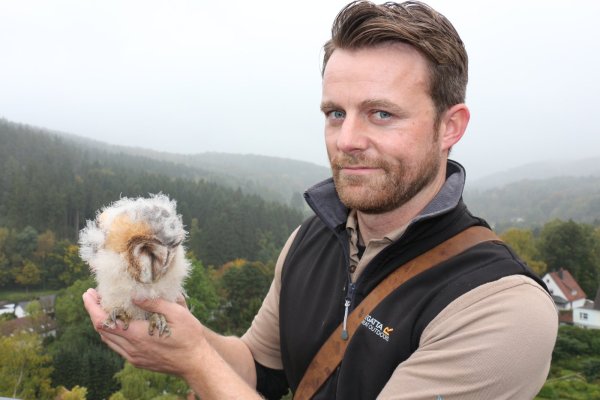 Falkner Benjamin Aschmann mit einem kleinen Patienten. Die Schleiereule ist ungefähr drei Wochen alt und im Teutoburger Wald aus dem Nest gefallen. - © Archivfoto: Janet König