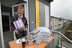 Fachbereichsleiter Rüdiger Winter zeigt, was zur Erstausstattung gehört: eine Garnitur Bettwäsche, Teller, Tasse, Töpfe und Besteck. - © Bernhard Preuß