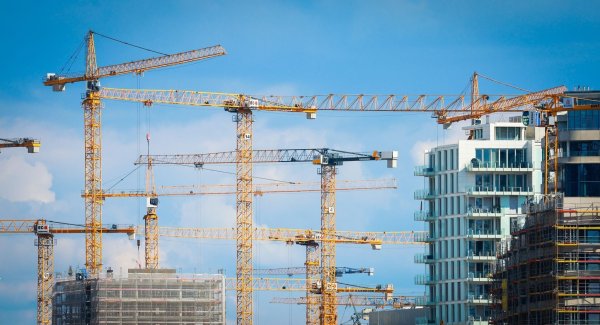 Baukräne stehen auf einer Baustelle in einer Innenstadt. - © Christian Charisius/dpa/Symbolbild