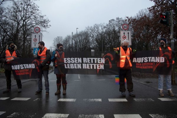 Klimaaktivisten der Gruppe Letzte Generation blockieren in Berlin eine Zufahrt zur Stadtautobahn. - © Paul Zinken/dpa